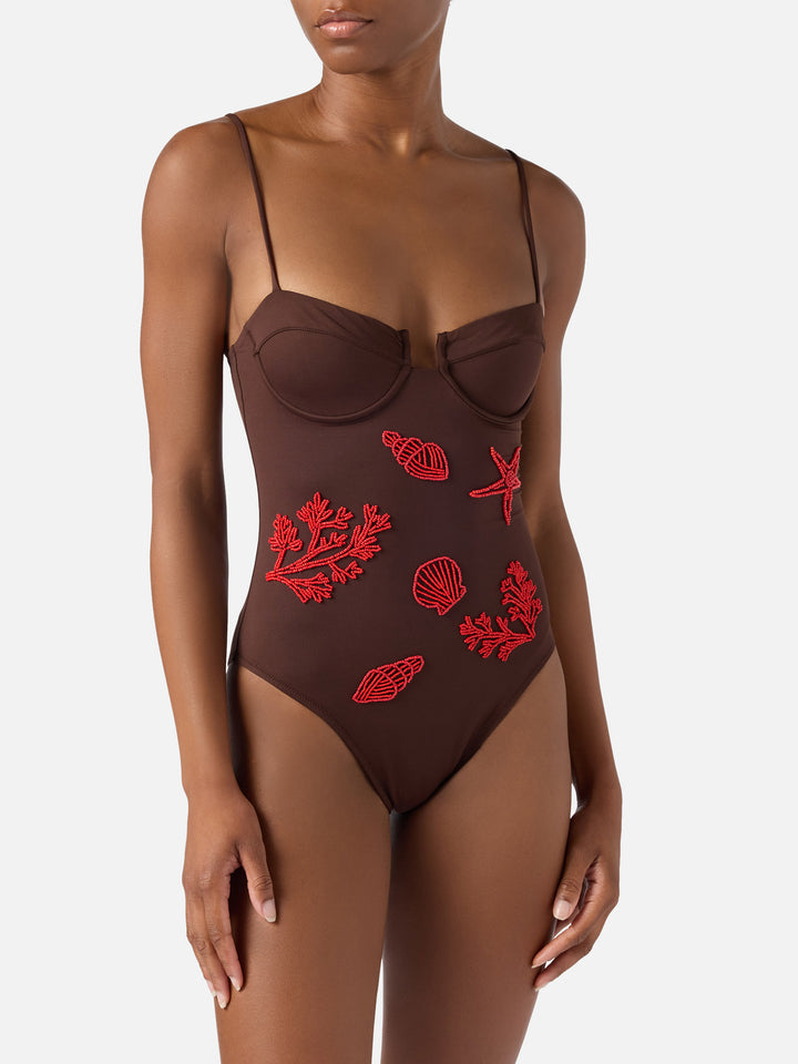 Medea one-piece swimsuit in brown with beaded sea-themed decorations